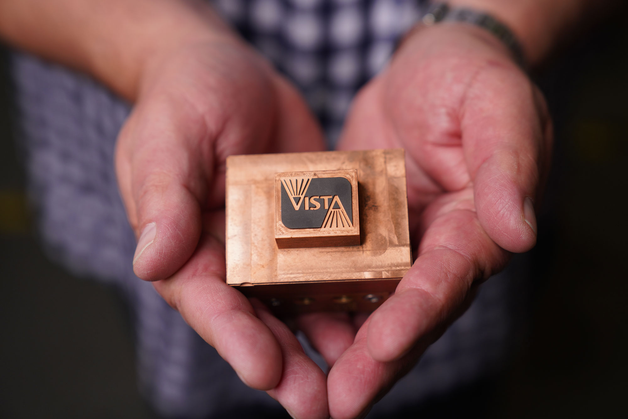 A person holds a lighting component marked with Vista Pro's logo